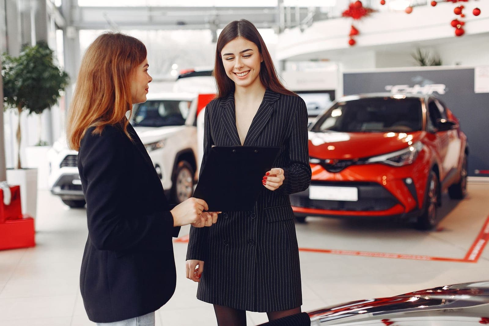 Nhân viên showroom ô tô trao đổi hợp đồng với khách hàng